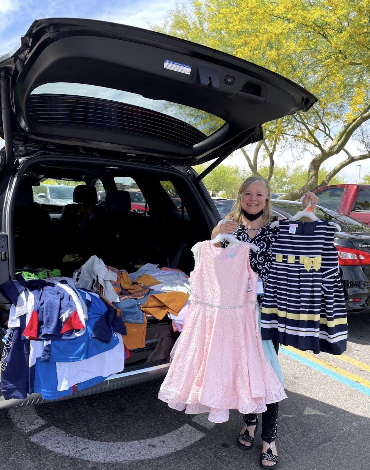 Ministry member holding girls dresses donated for the orphanage